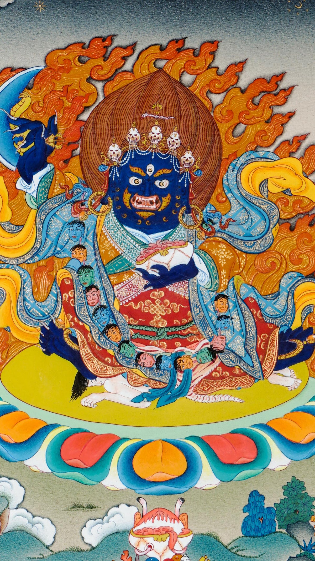 Tibetan thangka of Mahakala, the blue wrathful protector deity, holding a curved chopper and skull cup, surrounded by flames and seated on a lotus with symbolic offerings below.