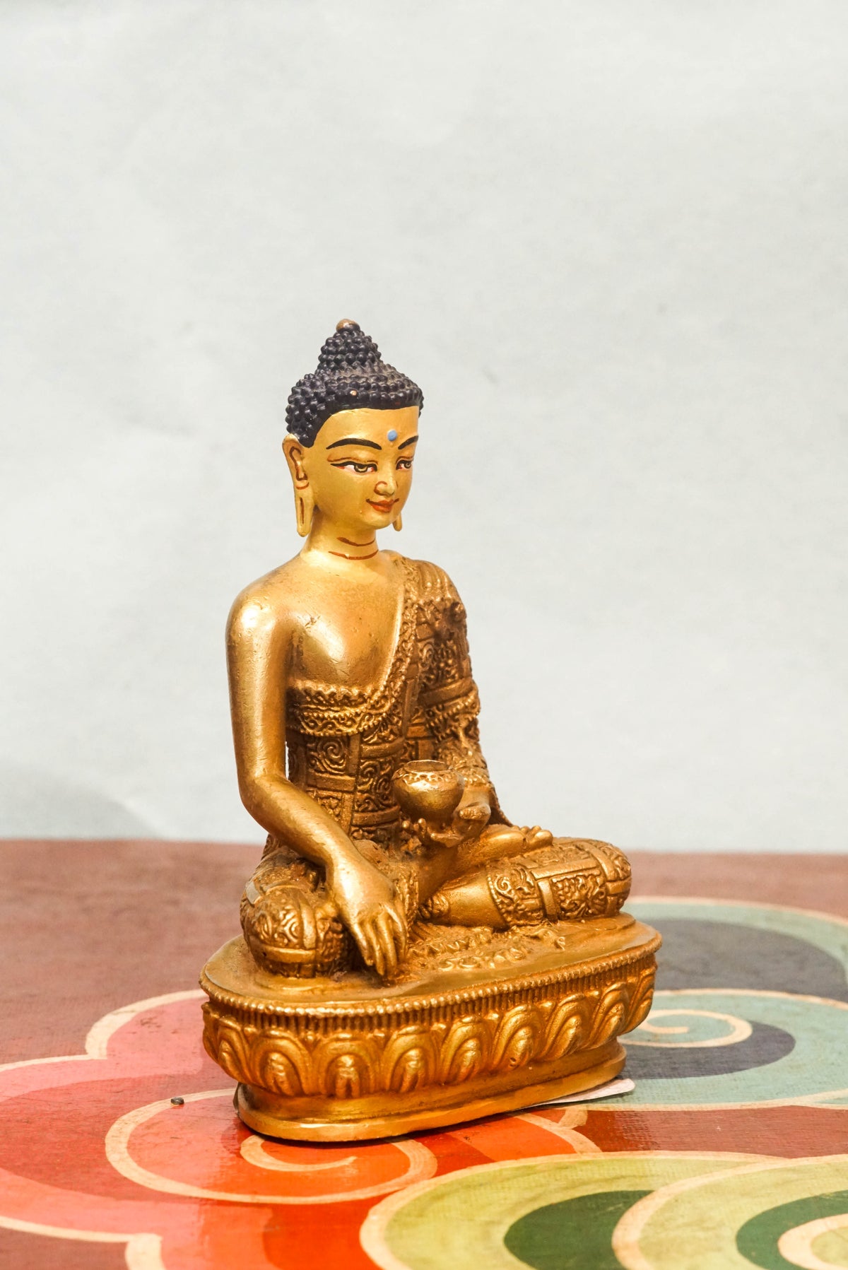 Handcrafted Shākyamuni Buddha statue seated in lotus posture with a radiant golden aura, symbolizing enlightenment, clarity, and spiritual presence.