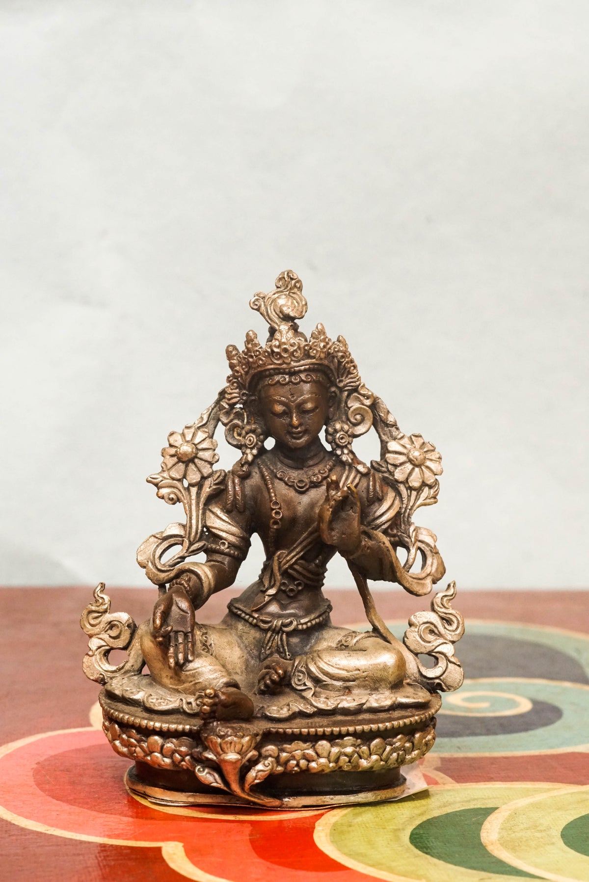 Green Tara statue crafted by skilled artisans, portraying the female deity,  adorned with traditional ornaments and symbolic gestures reflecting compassion, protection, and enlightened action.