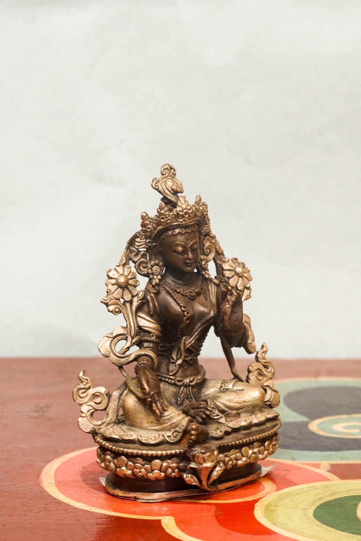 Green Tara statue crafted by skilled artisans, portraying the female deity,  adorned with traditional ornaments and symbolic gestures reflecting compassion, protection, and enlightened action.