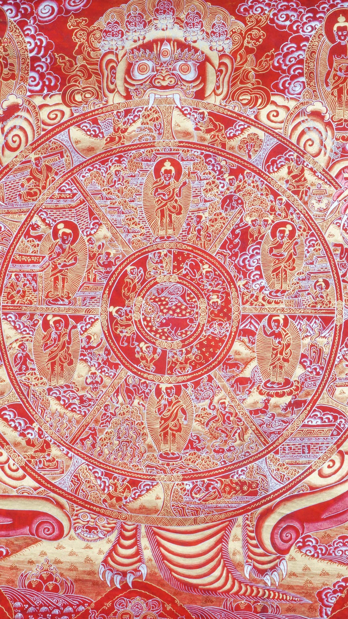 Red-toned thangka painting with gold and silver detailing, showing a large circular wheel divided into multiple sections filled with small human figures and scenes, held by a large multi-eyed figure at the top, surrounded by clouds, flames, and dense decorative patterns within a rectangular border.